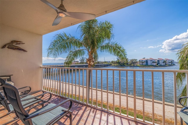 balcony featuring a water view and ceiling fan