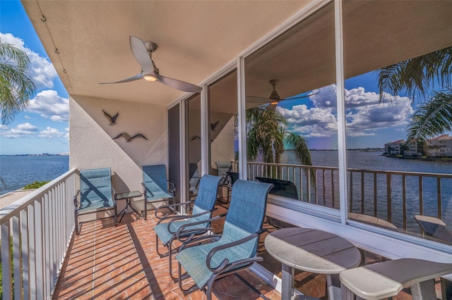 balcony with a water view and ceiling fan