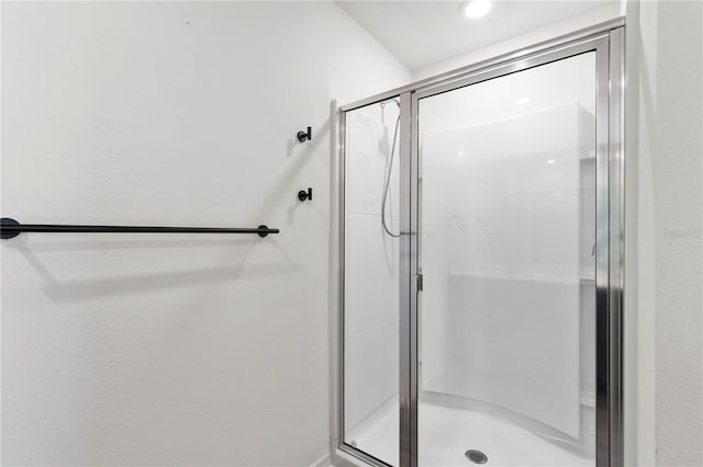 bathroom with a shower with door