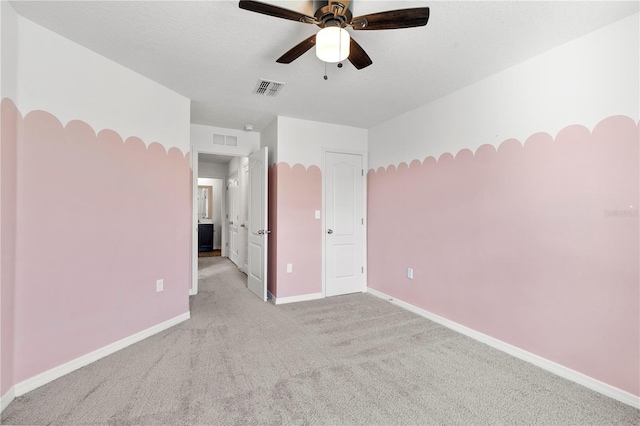 empty room featuring ceiling fan and light colored carpet