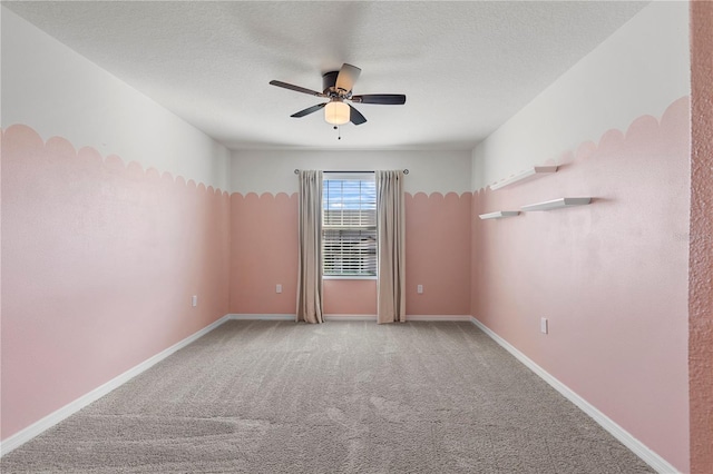 carpeted spare room featuring a textured ceiling and ceiling fan