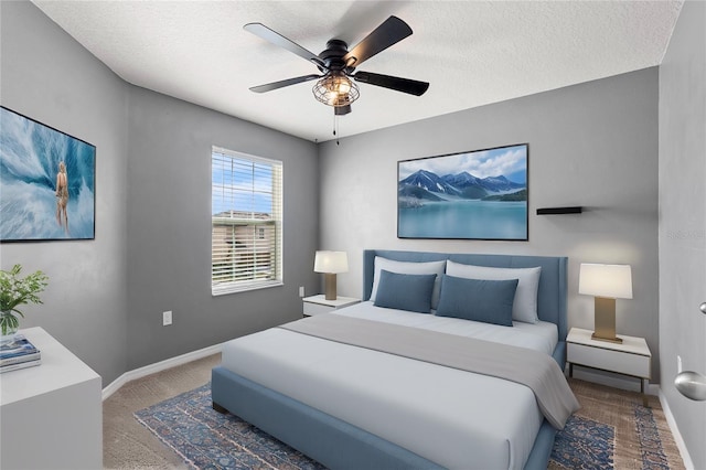 carpeted bedroom featuring ceiling fan and a textured ceiling