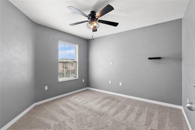 carpeted spare room with a textured ceiling and ceiling fan