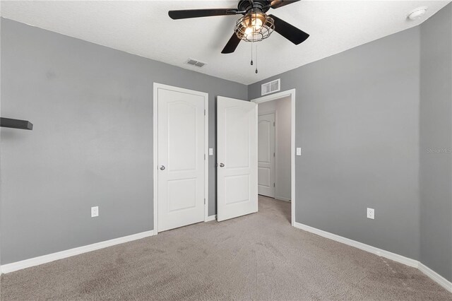 unfurnished bedroom featuring light colored carpet and ceiling fan