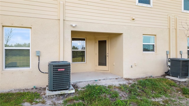 entrance to property featuring central air condition unit and a patio