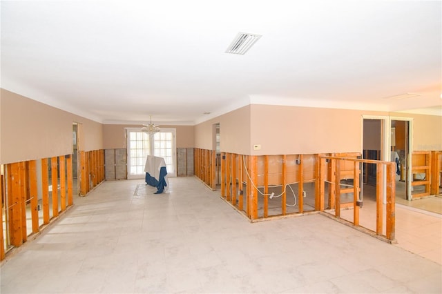 unfurnished room featuring a chandelier