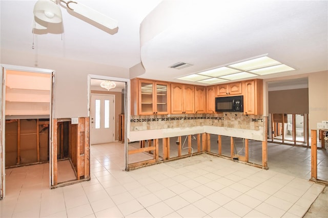 kitchen featuring backsplash, light tile patterned floors, and ceiling fan