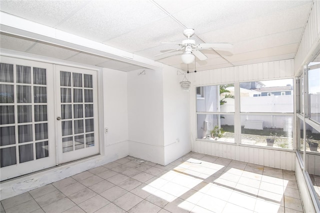 unfurnished sunroom featuring ceiling fan