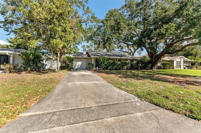 ranch-style home with a garage and a front lawn