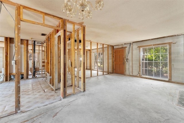 misc room with a chandelier and a textured ceiling