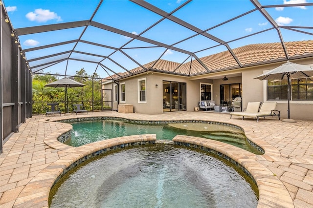 view of pool featuring glass enclosure, a patio, and an in ground hot tub