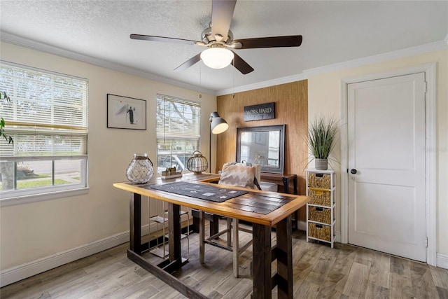 home office featuring ornamental molding, wood-type flooring, a textured ceiling, and ceiling fan