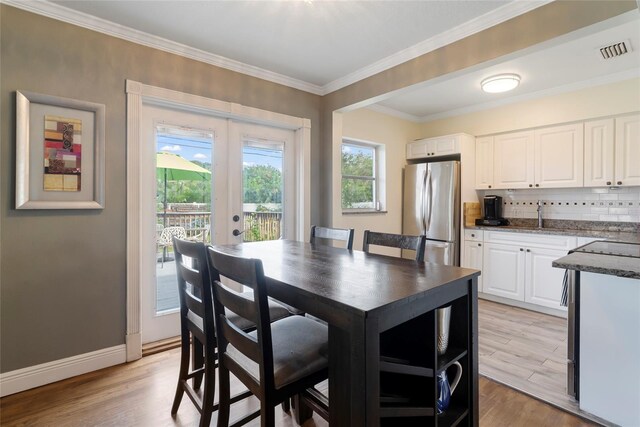 dining area featuring french doors, light hardwood / wood-style floors, and plenty of natural light