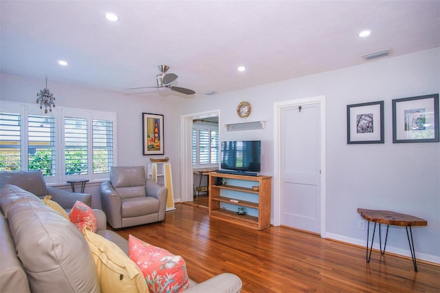 living room featuring ceiling fan and dark hardwood / wood-style floors