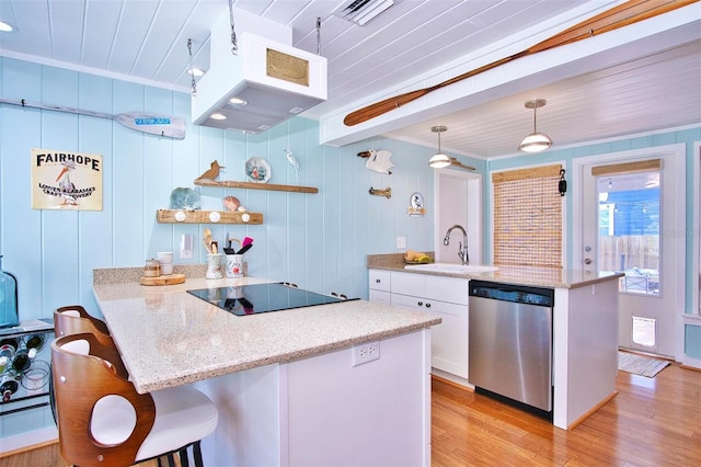 kitchen featuring dishwasher, black electric stovetop, sink, hanging light fixtures, and white cabinets