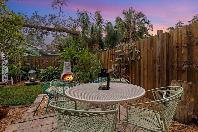 patio terrace at dusk with a fireplace