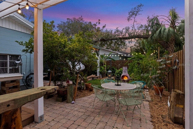 patio terrace at dusk with an outdoor fireplace