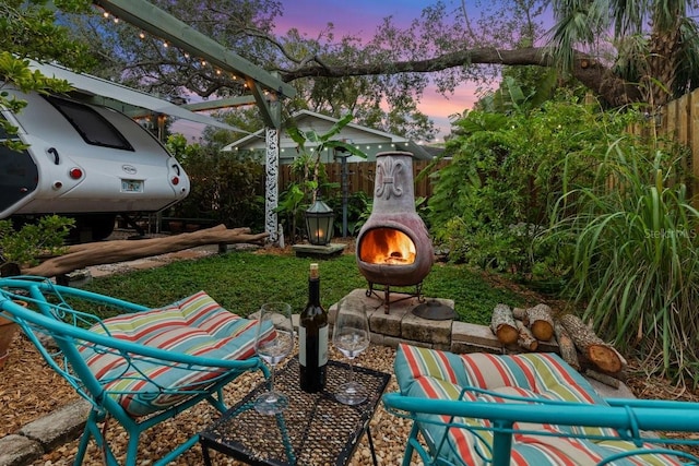 patio terrace at dusk featuring an outdoor fire pit