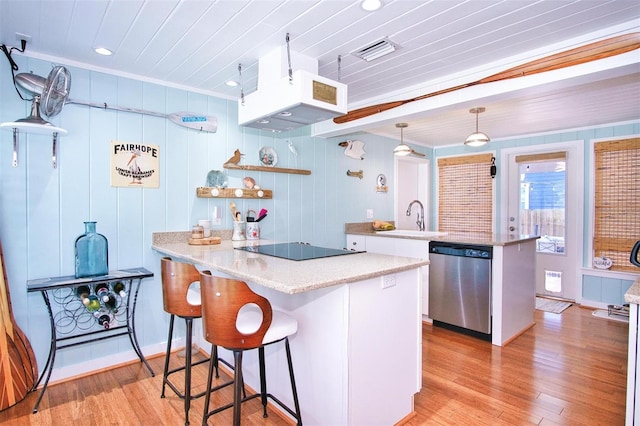 kitchen featuring stainless steel dishwasher, light wood-type flooring, hanging light fixtures, and white cabinetry