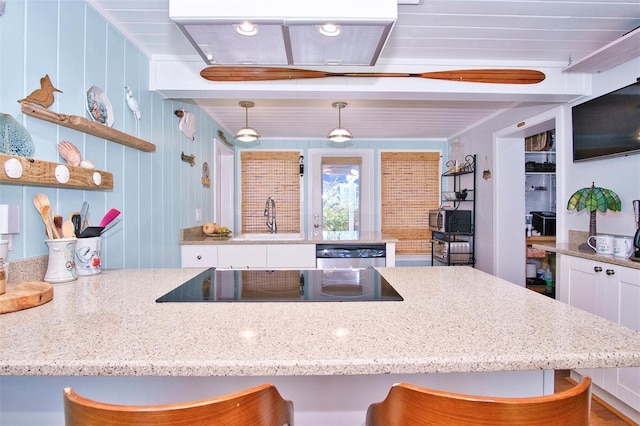 kitchen with white cabinetry, black electric stovetop, dishwasher, pendant lighting, and beam ceiling