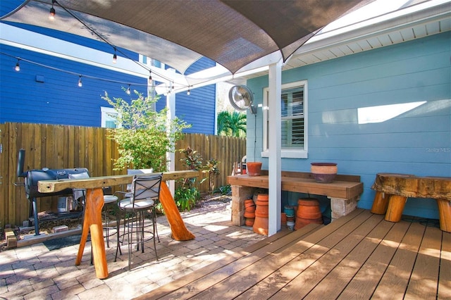 deck with exterior bar, a patio area, and grilling area