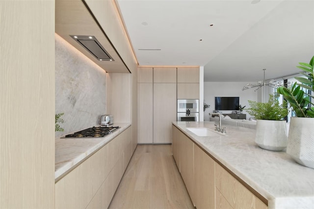 kitchen featuring light brown cabinets, appliances with stainless steel finishes, sink, and light hardwood / wood-style floors