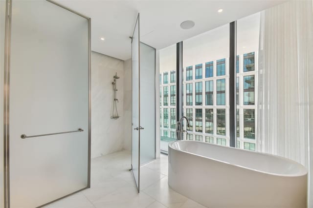 bathroom featuring separate shower and tub and floor to ceiling windows