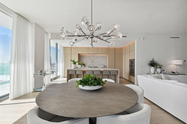 dining room featuring light wood-type flooring, an inviting chandelier, and a healthy amount of sunlight