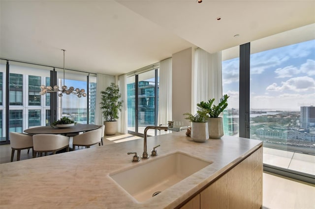 kitchen with expansive windows, a wealth of natural light, sink, and decorative light fixtures