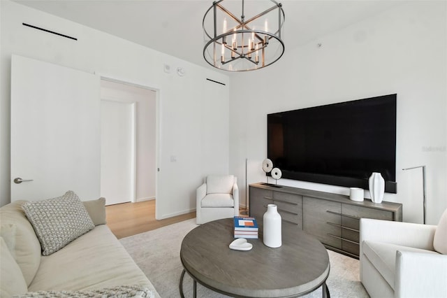 living room with light wood-type flooring and a chandelier