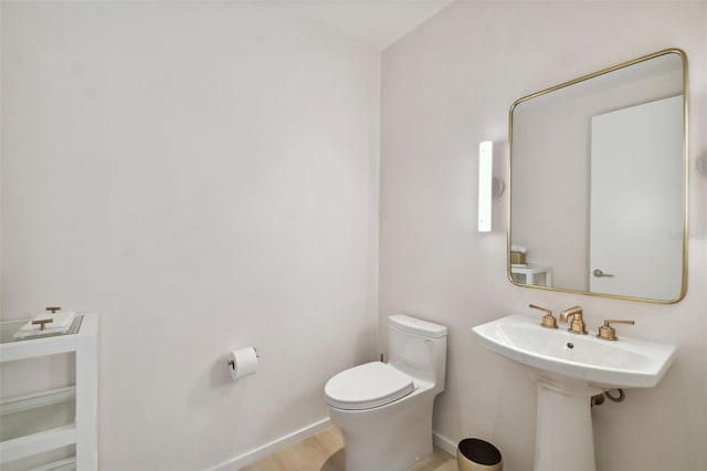 bathroom with wood-type flooring, sink, and toilet