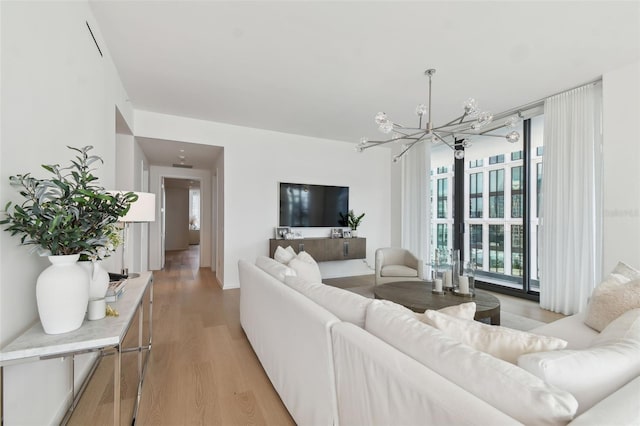 living room with a chandelier and light hardwood / wood-style floors