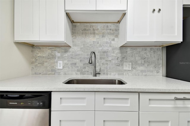 kitchen featuring dishwasher, sink, white cabinets, and backsplash