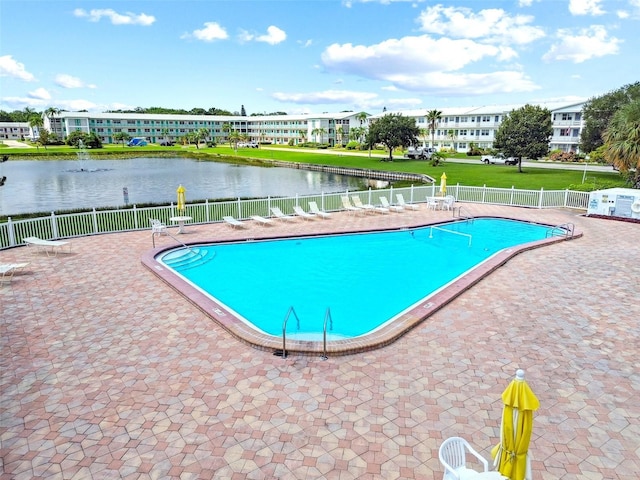 view of pool with a water view and a patio