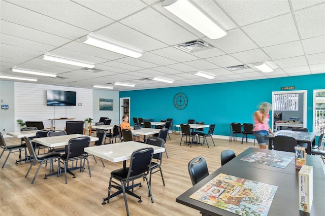 office area with a paneled ceiling and light hardwood / wood-style floors