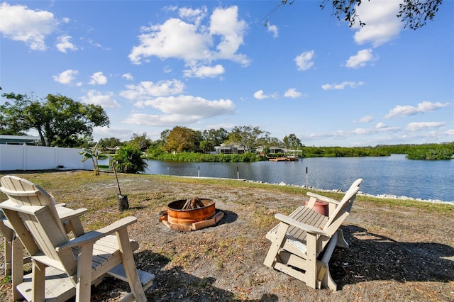 view of yard with an outdoor fire pit and a water view