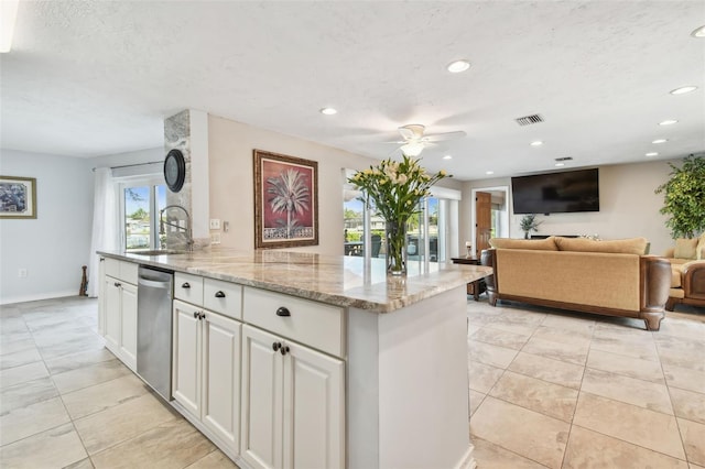 kitchen with ceiling fan, stainless steel dishwasher, sink, light stone countertops, and white cabinets