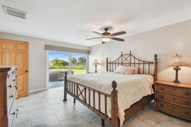 bedroom with a textured ceiling, ceiling fan, and access to outside