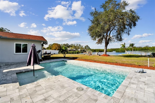 view of swimming pool with a patio area, a lawn, and a water view