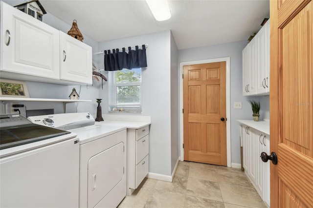 clothes washing area featuring cabinet space, baseboards, and separate washer and dryer