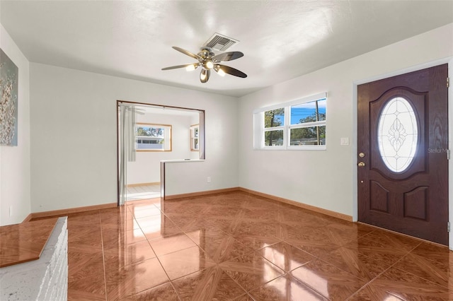 foyer with ceiling fan and tile patterned floors