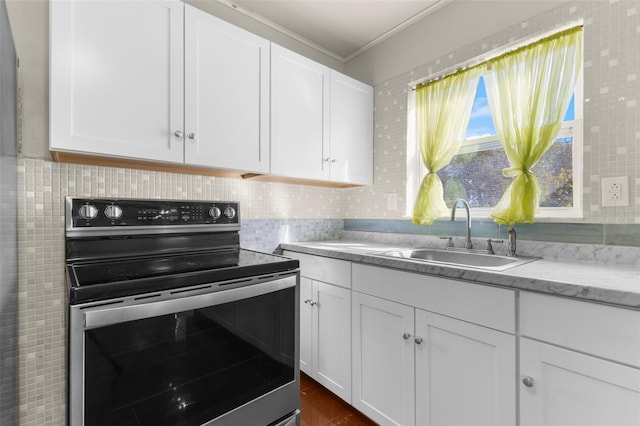 kitchen featuring white cabinetry, stainless steel electric range oven, sink, and crown molding