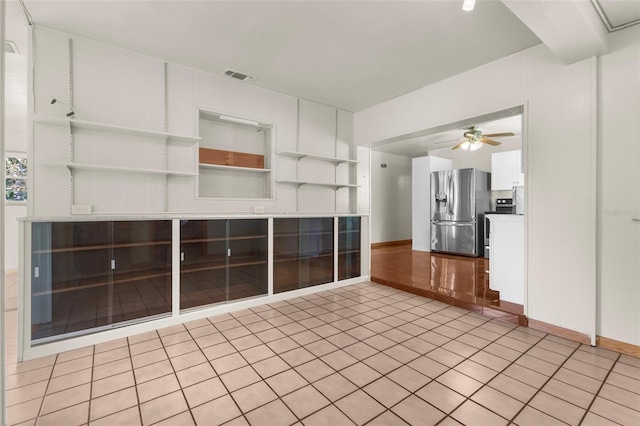 unfurnished living room with light tile patterned floors and ceiling fan