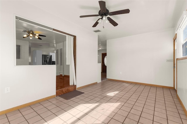 tiled empty room featuring ceiling fan