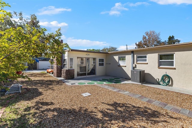 view of front of house featuring central AC unit, a patio, and a garage