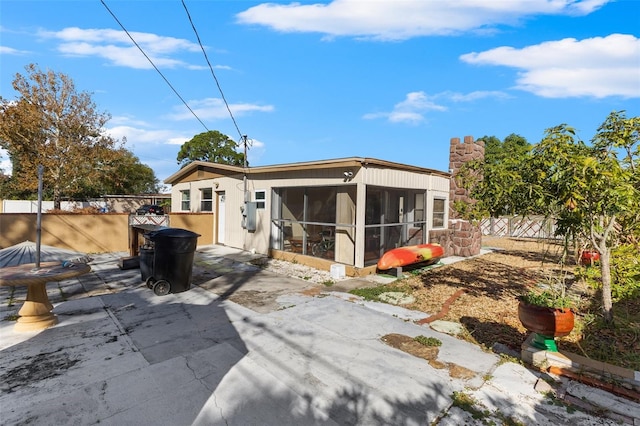 rear view of house featuring a sunroom and a patio