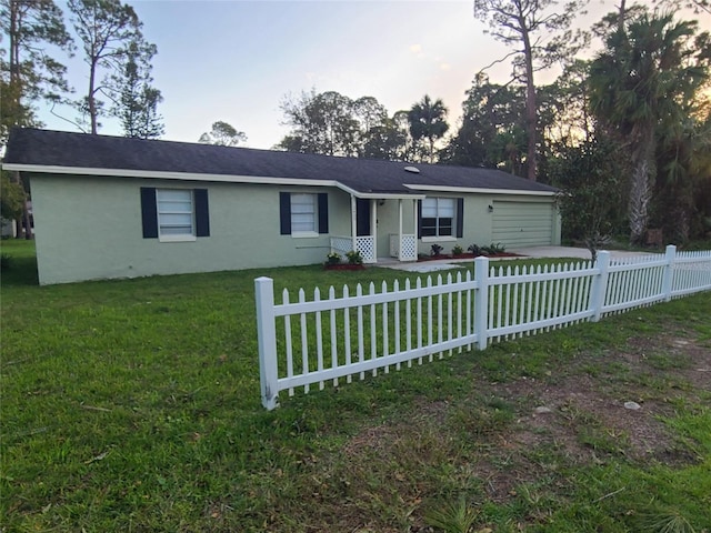 ranch-style house featuring a garage and a lawn