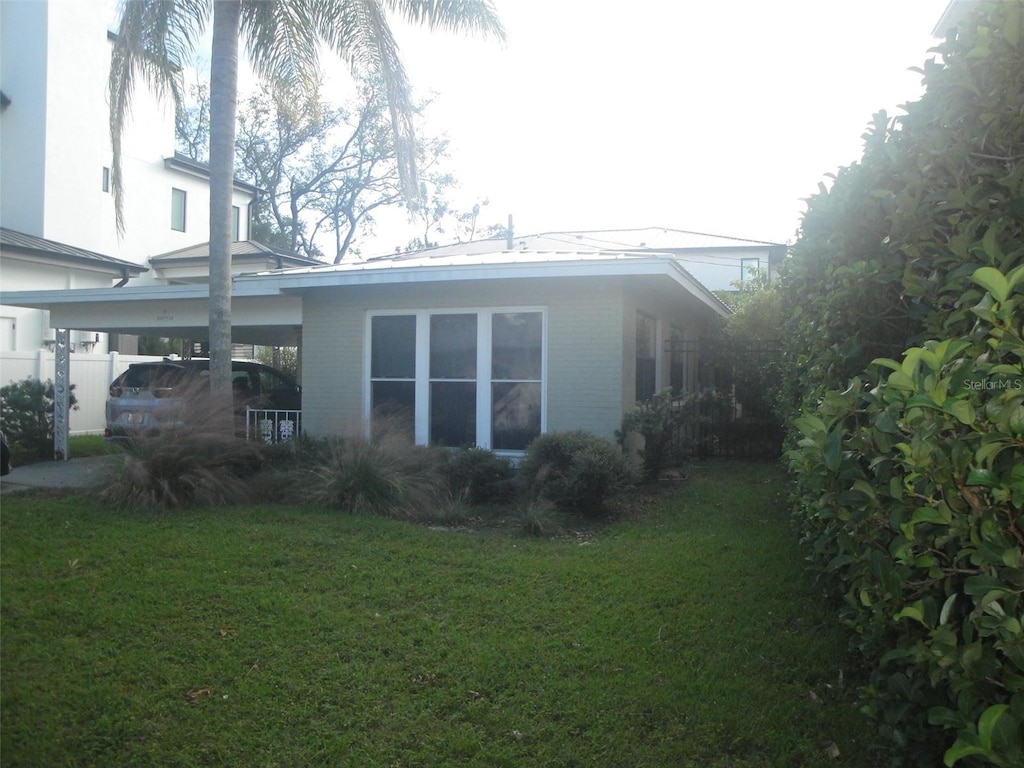 view of property exterior with a yard and a carport