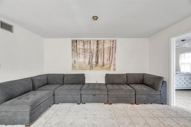 tiled living room featuring a textured ceiling