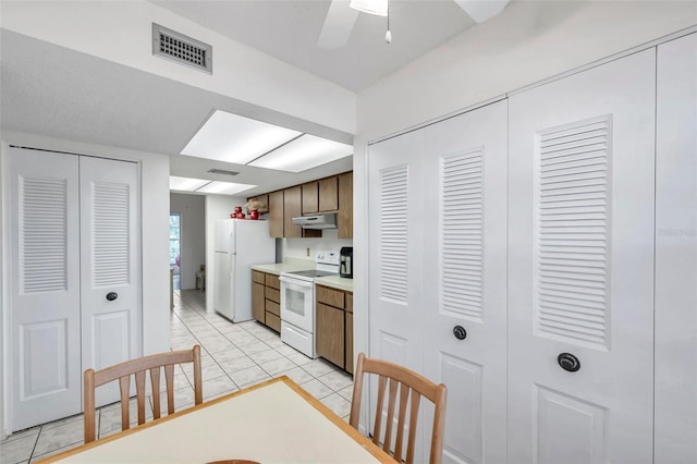 kitchen featuring white appliances, ceiling fan, and light tile patterned floors